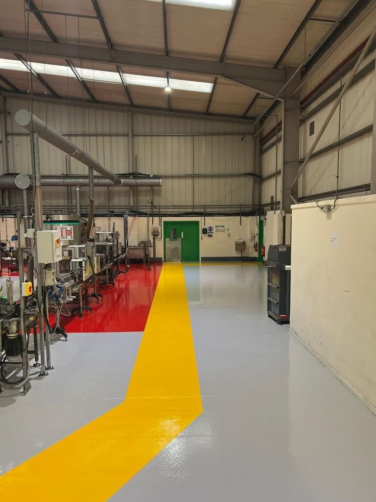 Resin floor demarcation to direct foot traffic at an aerosol filling manufacturer. 