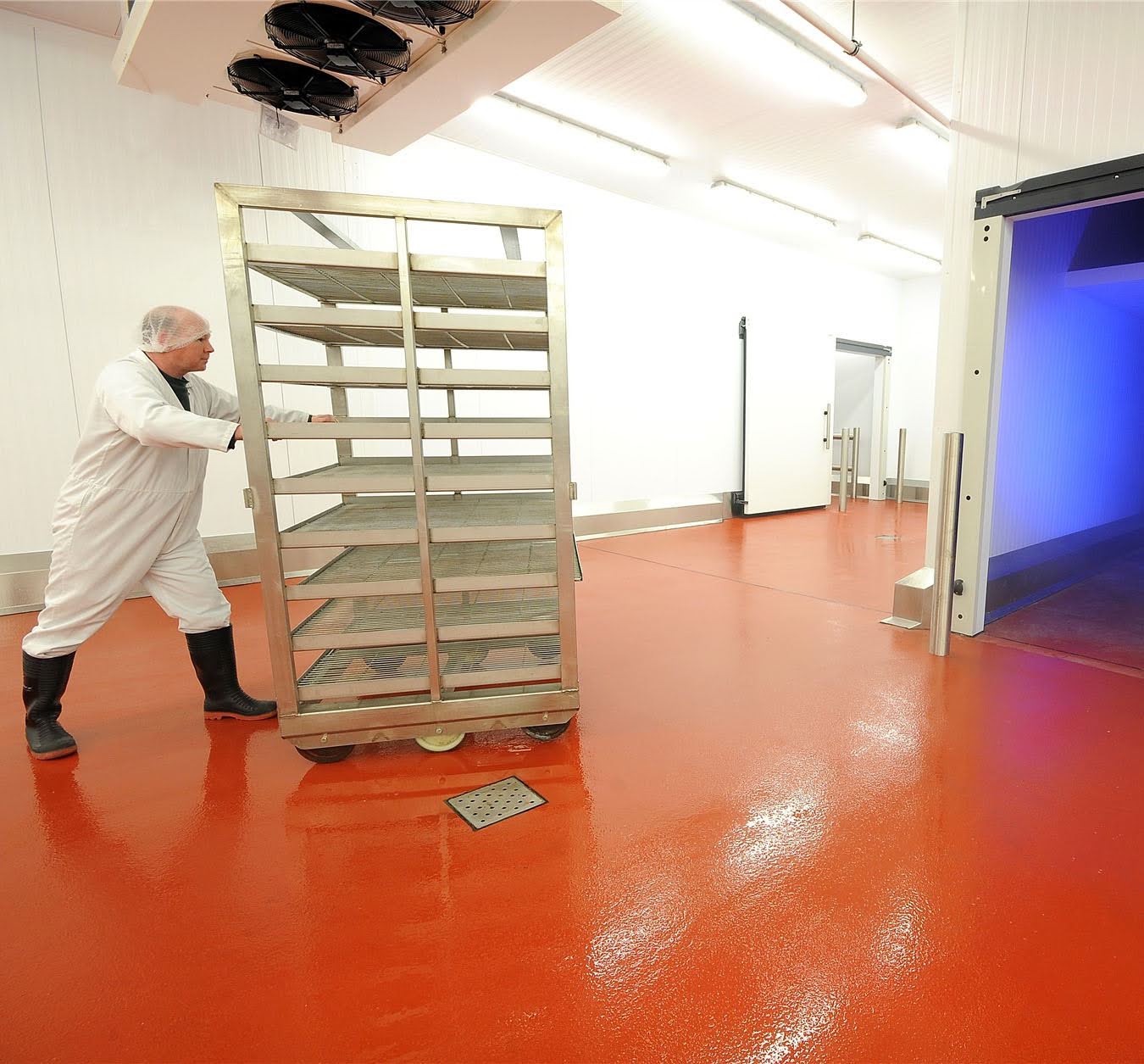 Worker moving equipment in a food factory on slip-resistant flooring 